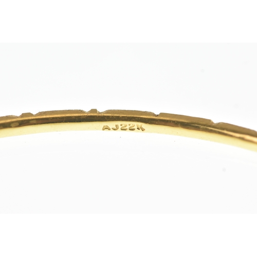 40 - A 22ct yellow gold bangle, of circular form and decorated with alternating faceted oval panels and e... 