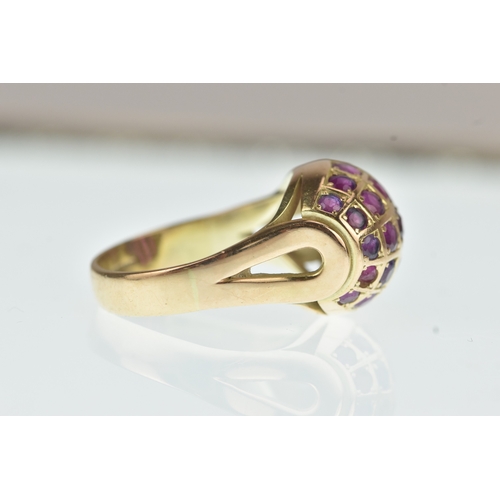 44 - A ruby 14ct yellow gold cluster ring, the domed oval panel inset with rows of circular cut rubies in... 