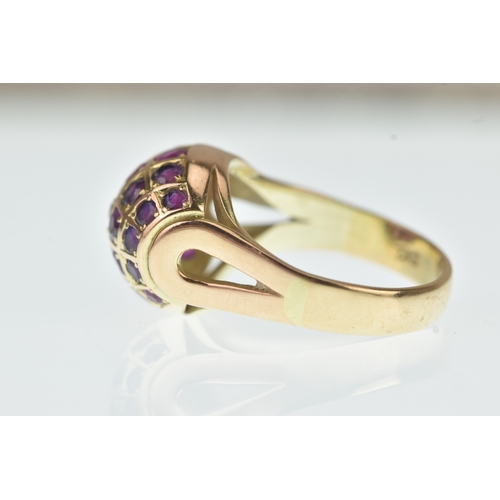 44 - A ruby 14ct yellow gold cluster ring, the domed oval panel inset with rows of circular cut rubies in... 