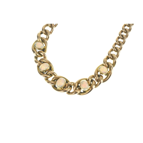 47 - A 15ct gold curb link bracelet, having graduating links interspersed with five oval opals in rubover... 