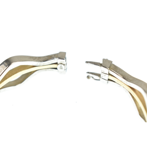 49 - A 14ct white and yellow gold bangle, having woven white gold bands enclosing a yellow gold band, con... 