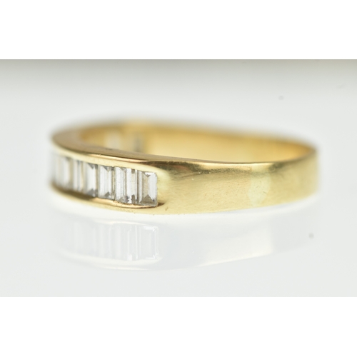 53 - A diamond yellow gold half eternity ring, unmarked, channel set with sixteen baguette cut diamonds, ... 