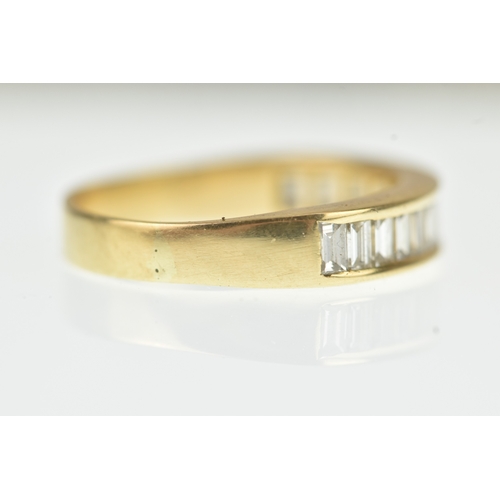 53 - A diamond yellow gold half eternity ring, unmarked, channel set with sixteen baguette cut diamonds, ... 