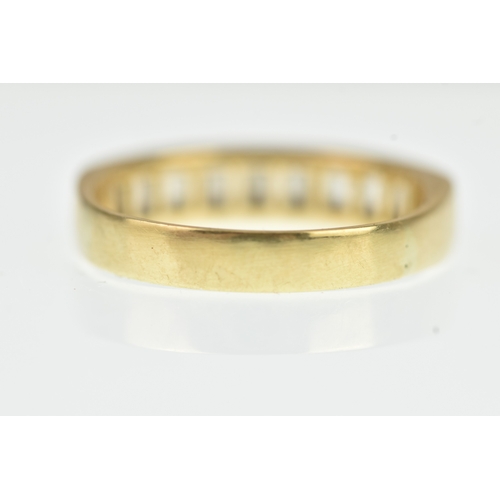 53 - A diamond yellow gold half eternity ring, unmarked, channel set with sixteen baguette cut diamonds, ... 