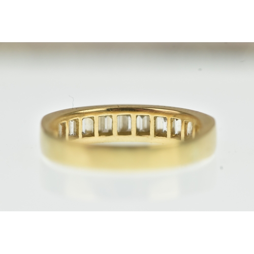 53 - A diamond yellow gold half eternity ring, unmarked, channel set with sixteen baguette cut diamonds, ... 