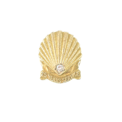 55 - A Shell 25 Year Service tie tack pin, in the form of a shell and inset with a single brilliant cut d... 