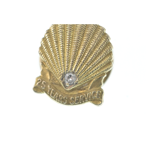 55 - A Shell 25 Year Service tie tack pin, in the form of a shell and inset with a single brilliant cut d... 