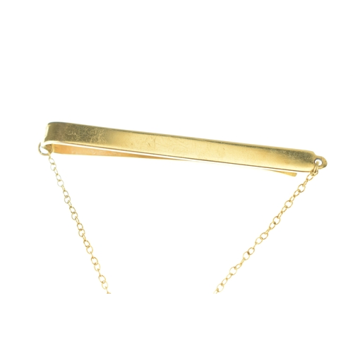 57 - A Shell 40 Year Service tie clip, suspending on chain links a shell inset with four brilliant cut di... 