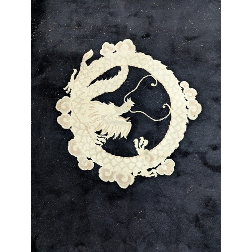 26 - A late 20th century Chinese washed woollen carpet with a dragon on a black ground 180 x 280cm Locati... 