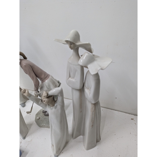 59 - A collection of Lladró porcelain figurines, including a Sea Captain figure, a Lladró group of nuns, ... 