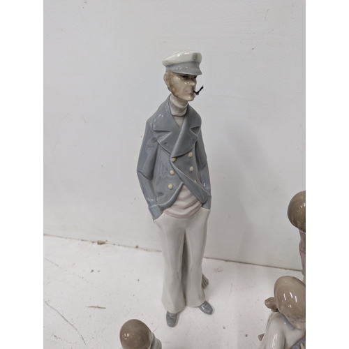 59 - A collection of Lladró porcelain figurines, including a Sea Captain figure, a Lladró group of nuns, ... 