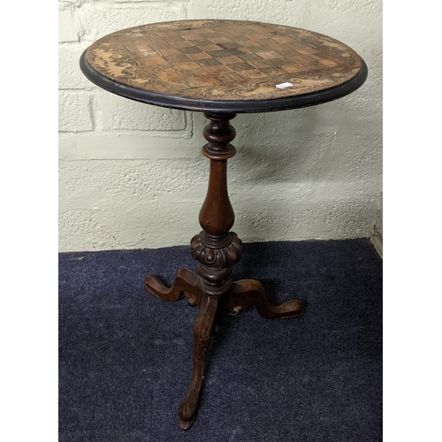 A Victorian marquetry inlaid games table having a circular top, turned ...