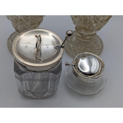 28 - A group of silver on glass items to include a pair of cut glass decanters A/F having silver collars ... 