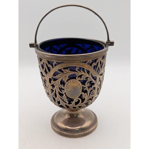 58 - A George V silver small pedestal basket with pierced c-scroll decoration and bird motifs, with blue ... 