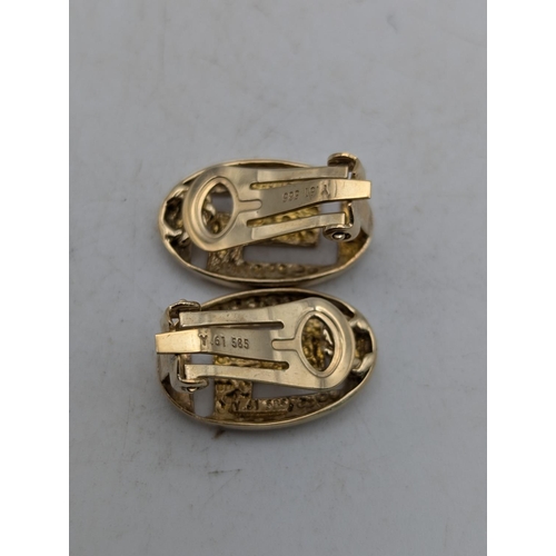 60 - A pair of 14ct gold clip on earrings in oval form, with pierced Greek key design, stamped 585, 4.4g
... 