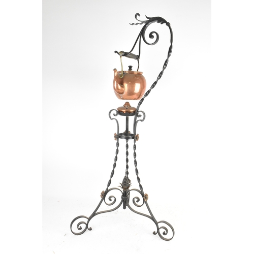 An Arts and Crafts wrought iron and copper hanging kettle stand, the ...