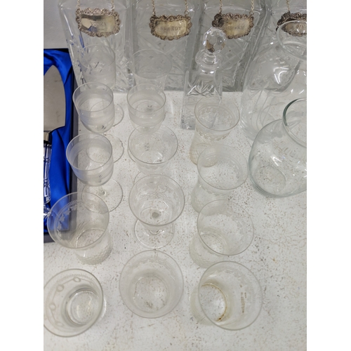 37 - A collection of glassware along with four crystal decanters all with decanter labels, one silver hal... 