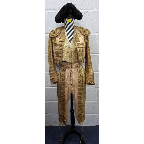 An early 20th Century gold coloured matador/toreador 'suit of lights', comprising a short silk jacket, waistcoat and trousers, heavily embroidered with applied gold coloured sequins and raised gold wire disc sequences together with a black embroidered Montera (hat). Location:Mannequin
If there is no condition report, please request