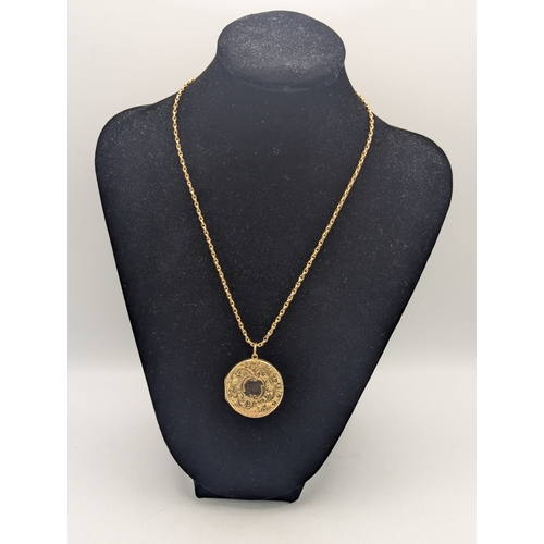 A Victorian 9ct yellow gold two sided locket in circular form having floral scroll decoration, with central cartouche, on a 9ct yellow gold necklace with spring ring clasp, total weight 12.5g
Location:
If there is no condition report shown, please request