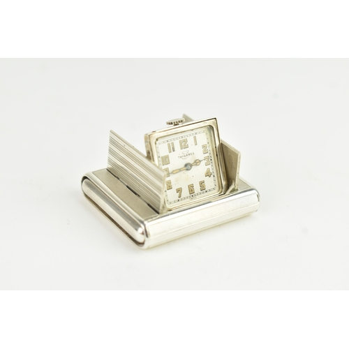 5 - An Art Deco Tavannes silver purse watch, having an engine turned case, twin buttons operating the me... 