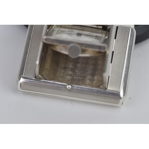5 - An Art Deco Tavannes silver purse watch, having an engine turned case, twin buttons operating the me... 