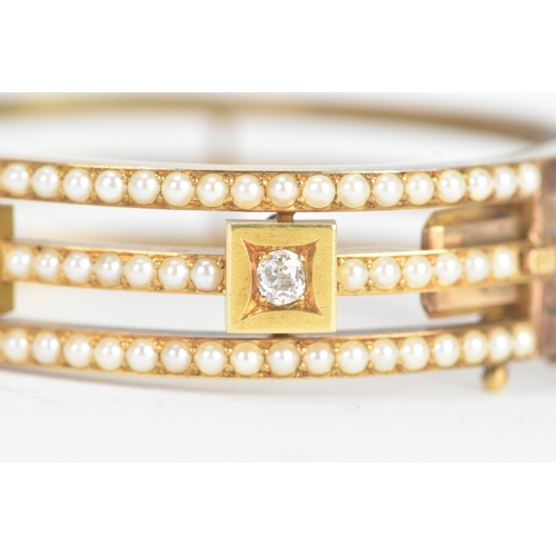 16 - A late Victorian seed pearl and diamond yellow gold hinged bangle, unmarked, of openwork triple-band... 