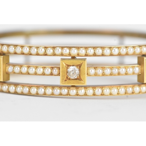 16 - A late Victorian seed pearl and diamond yellow gold hinged bangle, unmarked, of openwork triple-band... 
