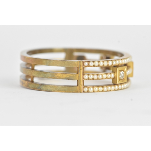 16 - A late Victorian seed pearl and diamond yellow gold hinged bangle, unmarked, of openwork triple-band... 