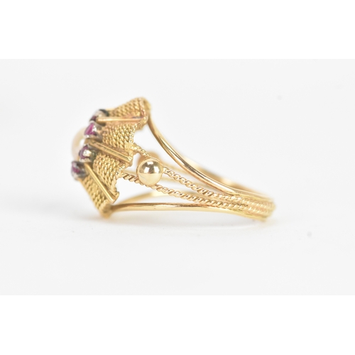 17 - A pearl and ruby yellow gold dress ring, unmarked, the flowerhead cluster centred by a pearl within ... 