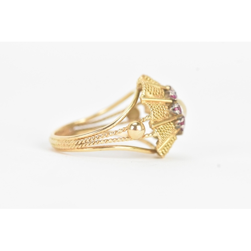 17 - A pearl and ruby yellow gold dress ring, unmarked, the flowerhead cluster centred by a pearl within ... 