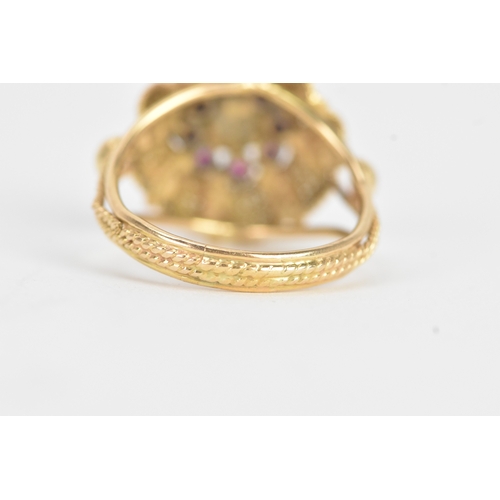 17 - A pearl and ruby yellow gold dress ring, unmarked, the flowerhead cluster centred by a pearl within ... 
