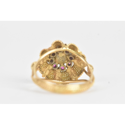 17 - A pearl and ruby yellow gold dress ring, unmarked, the flowerhead cluster centred by a pearl within ... 