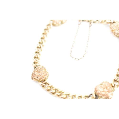 19 - A yellow gold curb link chain bracelet, unmarked, the curb links interspersed with four heart shaped... 