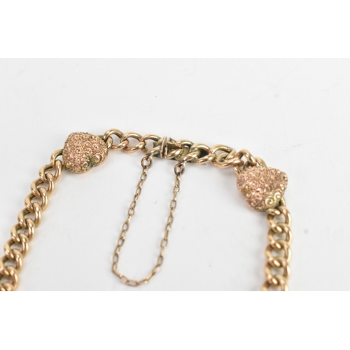 19 - A yellow gold curb link chain bracelet, unmarked, the curb links interspersed with four heart shaped... 