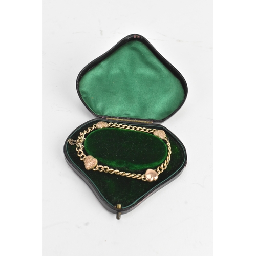 19 - A yellow gold curb link chain bracelet, unmarked, the curb links interspersed with four heart shaped... 