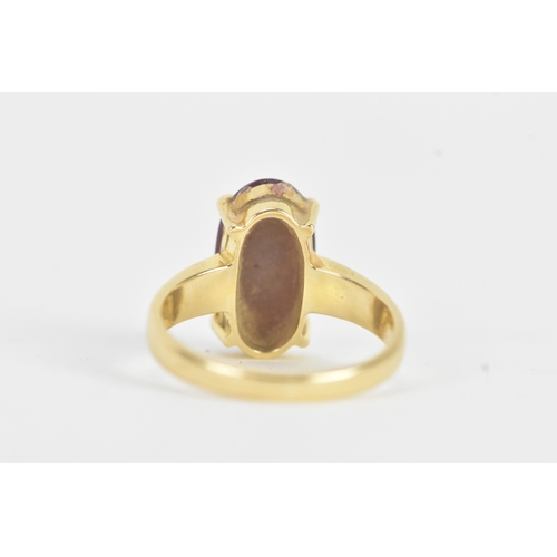 25 - An 18ct gold dress ring, set with a large oval cabochon in a four claw setting, measuring approximat... 
