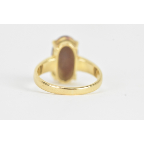 25 - An 18ct gold dress ring, set with a large oval cabochon in a four claw setting, measuring approximat... 
