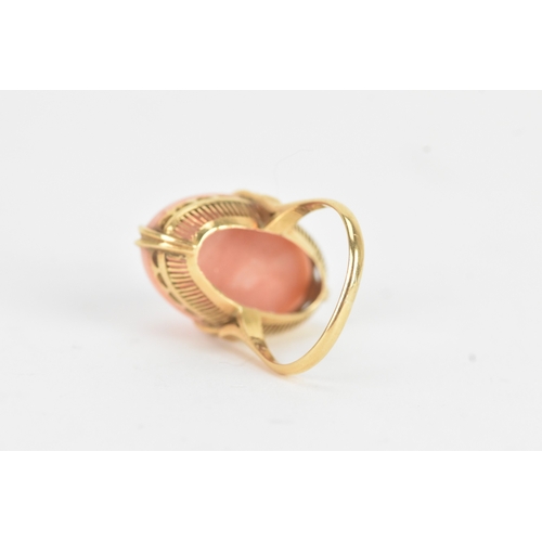 27 - A coral 18ct yellow gold dress ring, the large oval coral in a four claw setting measuring approxima... 