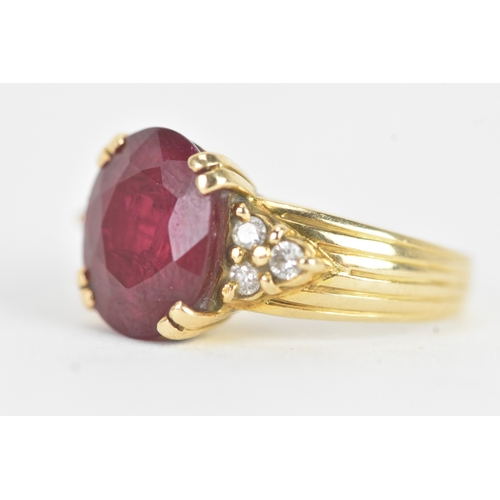28 - A ruby and diamond 18ct gold ring, the oval ruby in a four claw setting measuring approximately 11.2... 