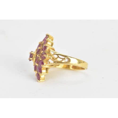 29 - A ruby 18ct yellow gold cluster dress ring, of radiating flower head design, set with twenty-one rub... 