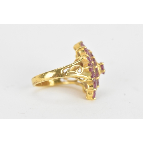 29 - A ruby 18ct yellow gold cluster dress ring, of radiating flower head design, set with twenty-one rub... 