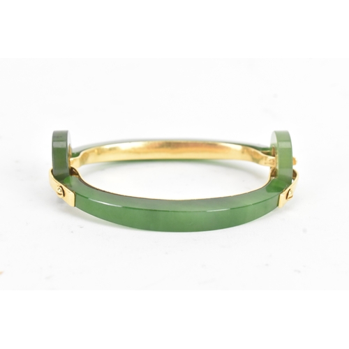 30 - A jade 18ct gold articulated bangle, composed of two curved and two circular polished jade sections ... 
