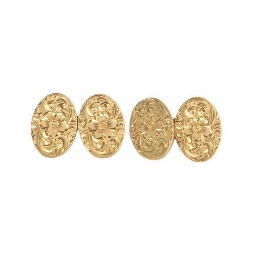 31 - A pair of 14ct yellow gold cufflinks, in oval form, having floral engraved decoration. 14mm x 11.7mm... 