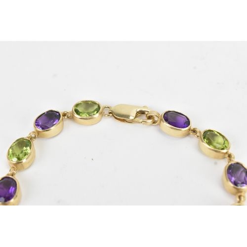 32 - A 9ct yellow gold bracelet featuring alternating oval-cut amethyst and peridots in a rub over settin... 