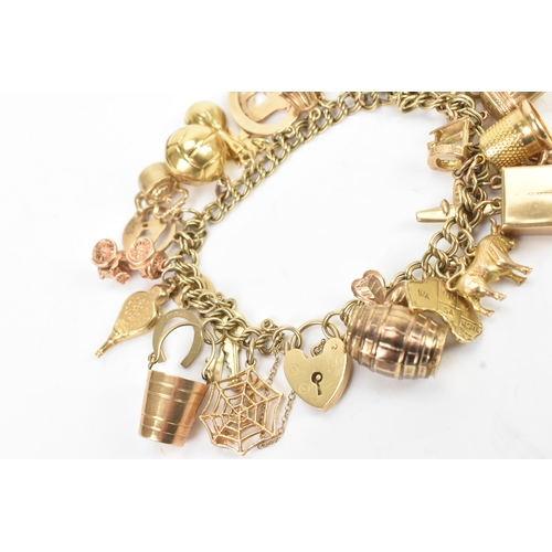 37 - A 9ct yellow gold double link charm link bracelet, having a heart shaped padlock clasp, having a lar... 