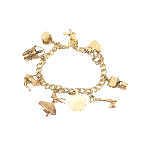 38 - A 9ct yellow gold charm bracelet having a heart shaped padlock clasp, with eight 9ct yellow gold cha... 