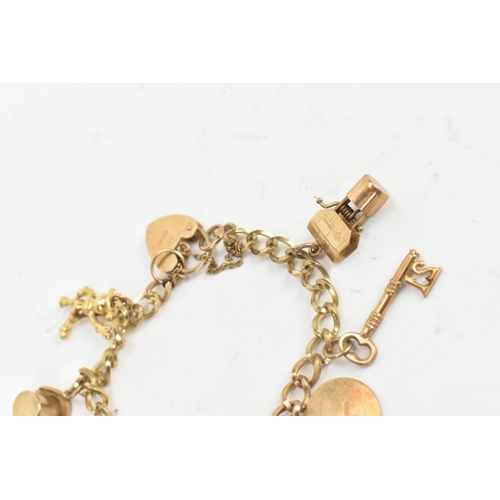 38 - A 9ct yellow gold charm bracelet having a heart shaped padlock clasp, with eight 9ct yellow gold cha... 