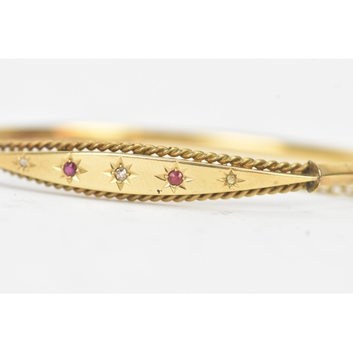 45 - A Victorian starburst set diamond and ruby 9ct yellow gold bangle,  featuring alternating round face... 