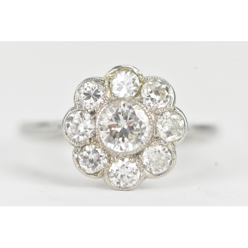 48 - A diamond 18ct white gold and platinum daisy ring, featuring a central bezel set brilliant round cut... 