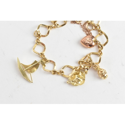 55 - A 14ct yellow gold fancy link charm bracelet, stamped 14K, having yellow gold charms, to include a p... 